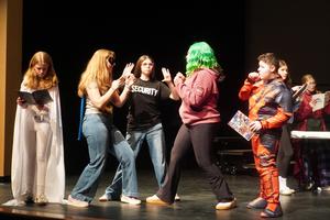 Several students engage in a scene from the play.
