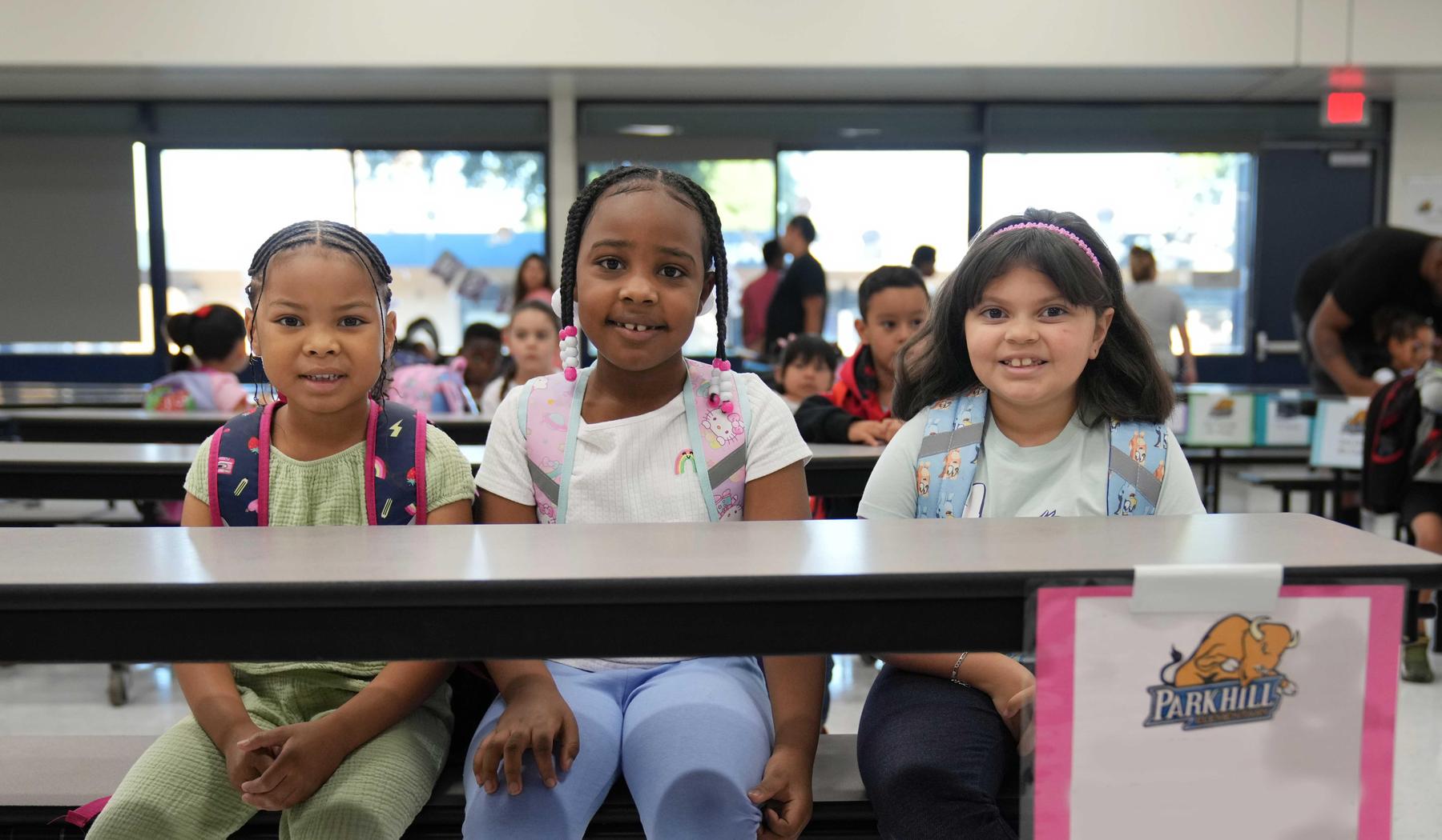 three girls sitting a lunch table