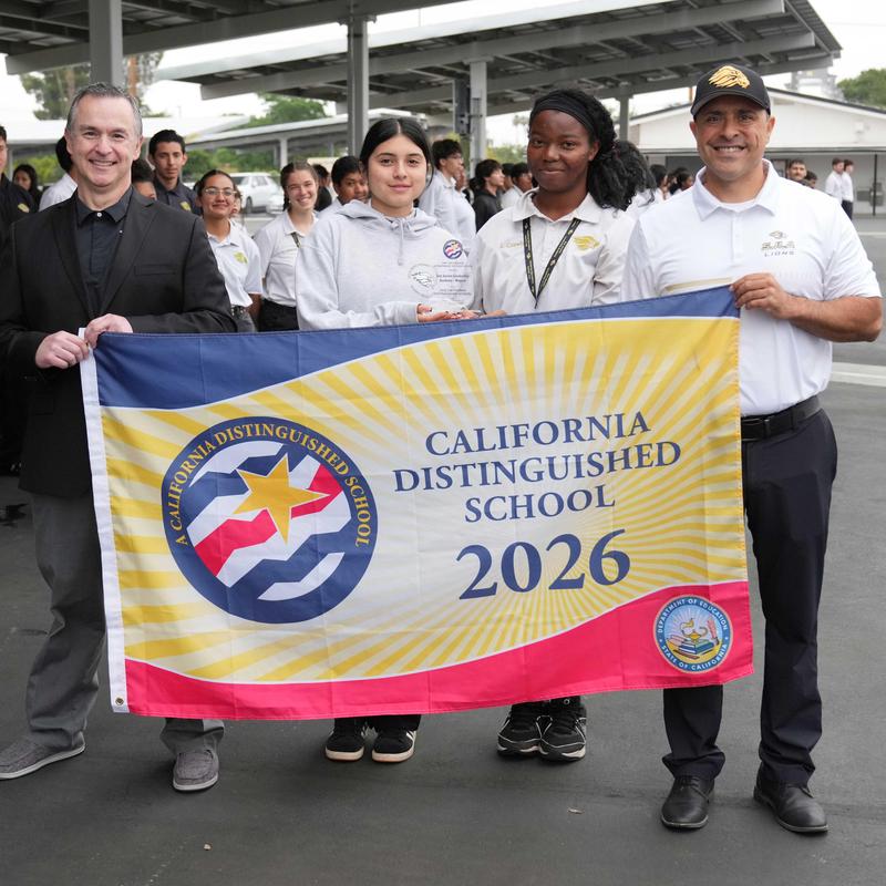 People holding Distinguished School banner