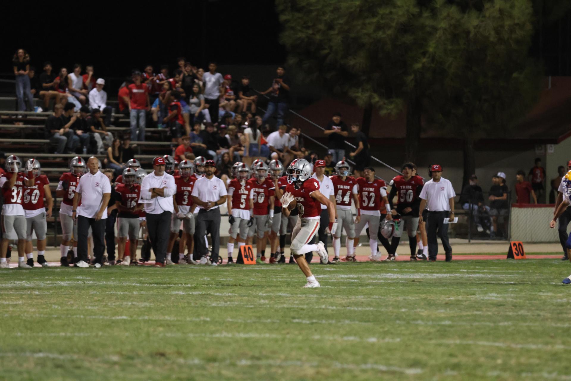Varsity football players in action against Parlier 24