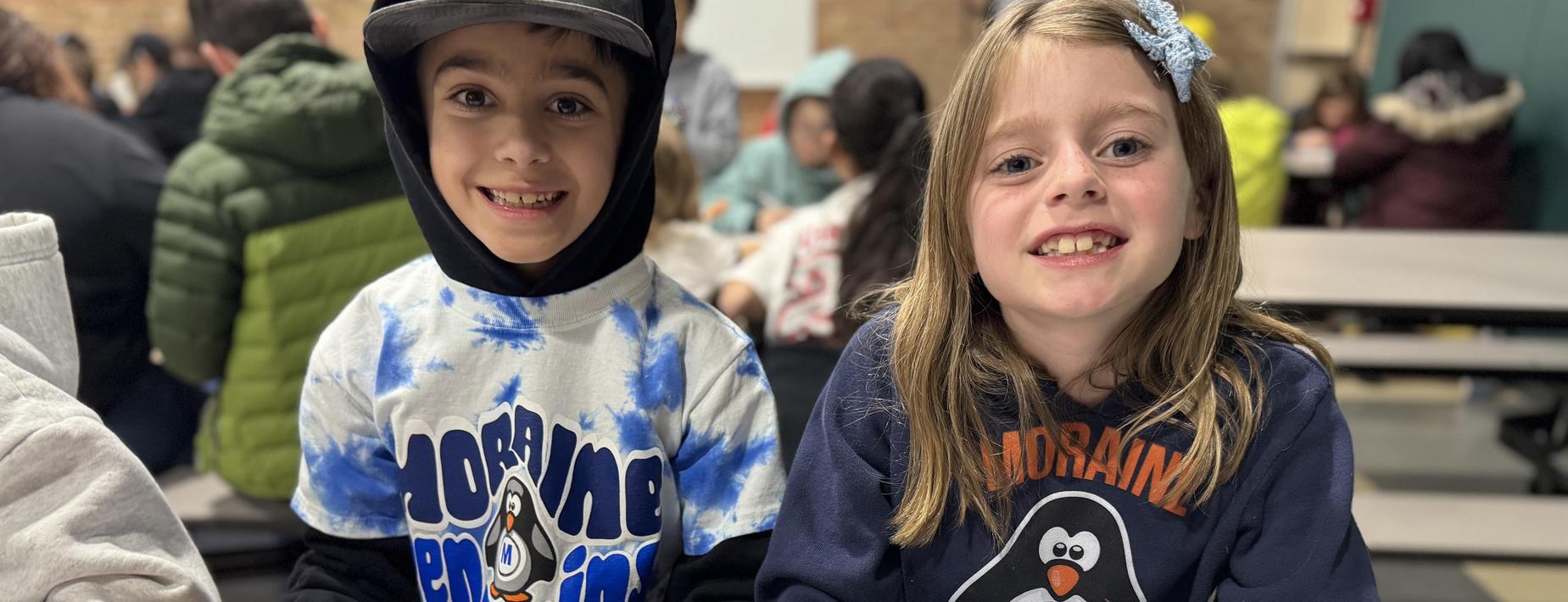 Two smiling students with Moraine swag on.