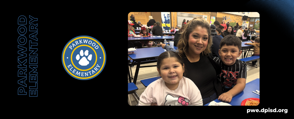 A woman and two children smiling together at a dining table in a school setting.
