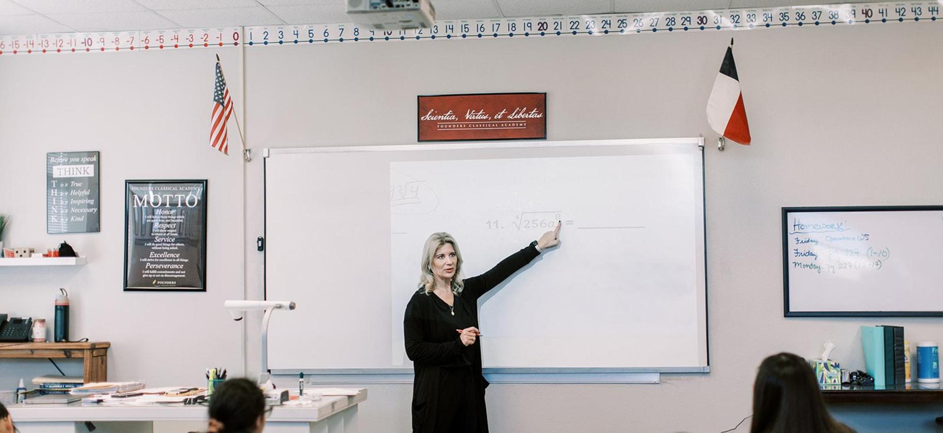 Teacher points to the whiteboard during a lesson