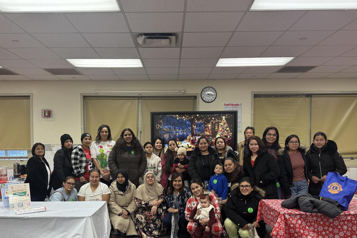A large group of diverse women and children gathered in a room decorated for an event.