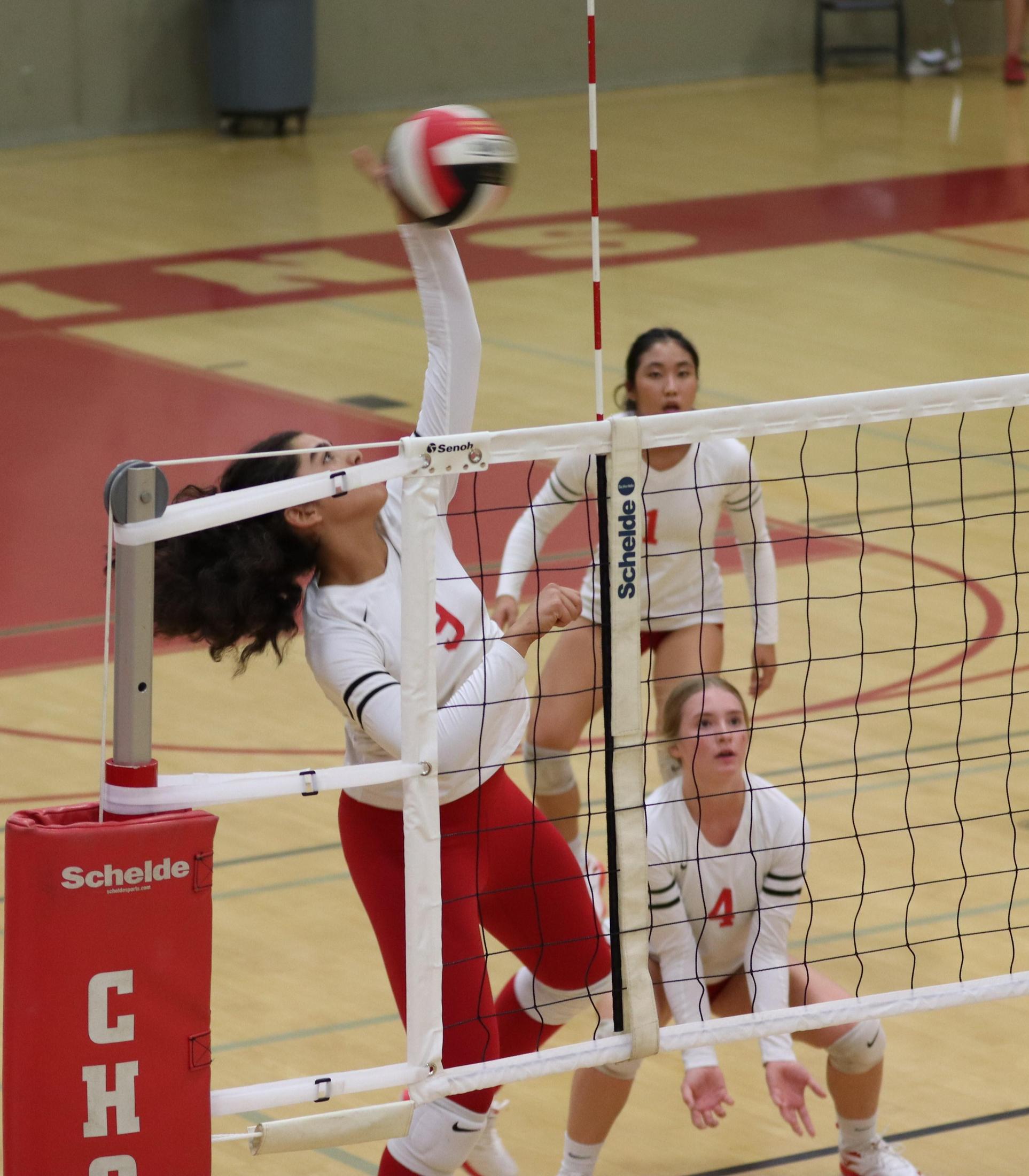 varsity volleyball players in action against Fresno Christian
