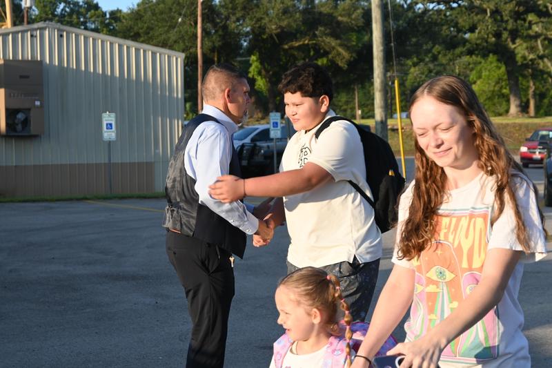 Mr. Everett shaking hands with kids coming into the school.