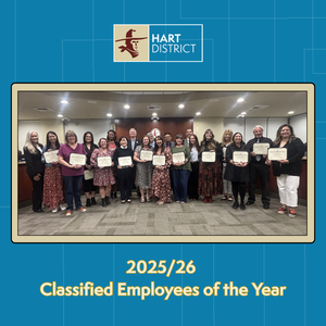 A group of classified employees and board members holding certificates and smiling.