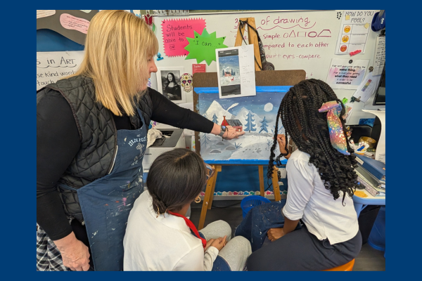 Art teacher working with a student on her project.