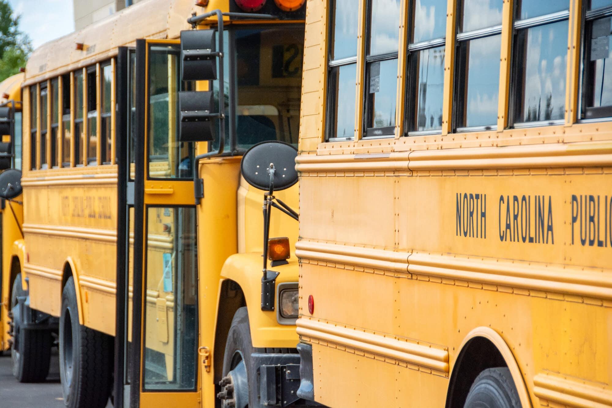 A photo of yellow school buses with their doors open 