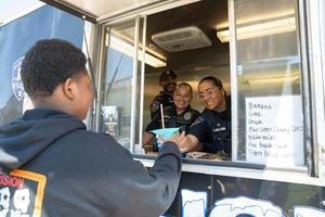 Temple police officers serve a snow cone to a student