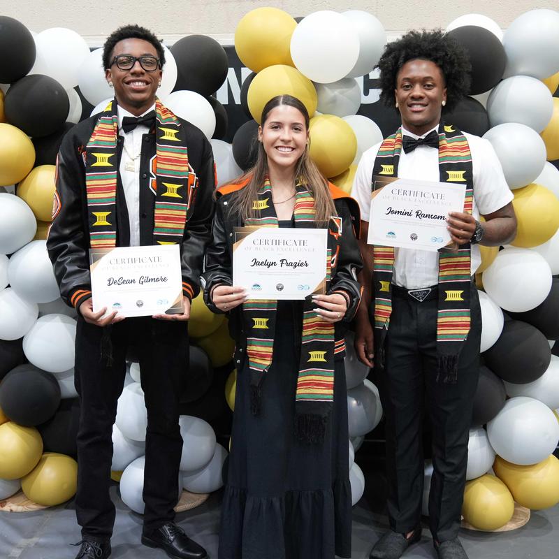 three students holding certificates at the Black Excellence Awards