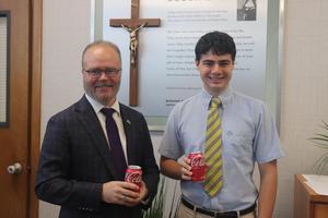 Principal Sean Kane and Liam Sheehan holding coca cola cans