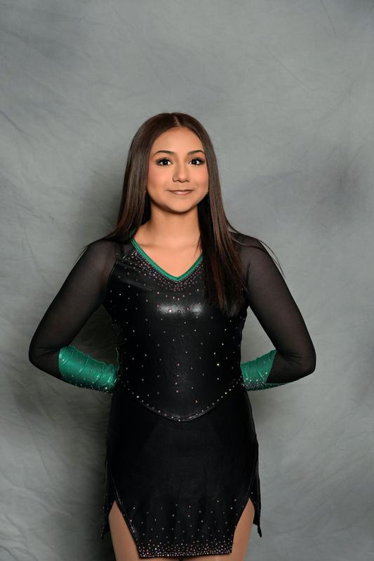 Female athlete poses in front of grey background