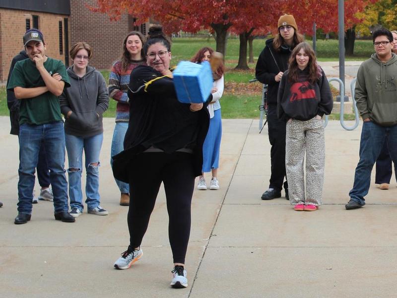 TKHS English teacher Cary Saxton uses the bat as the final challenge for the packages.