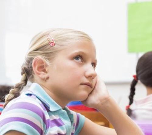 Young girl not paying attention to teacher in school