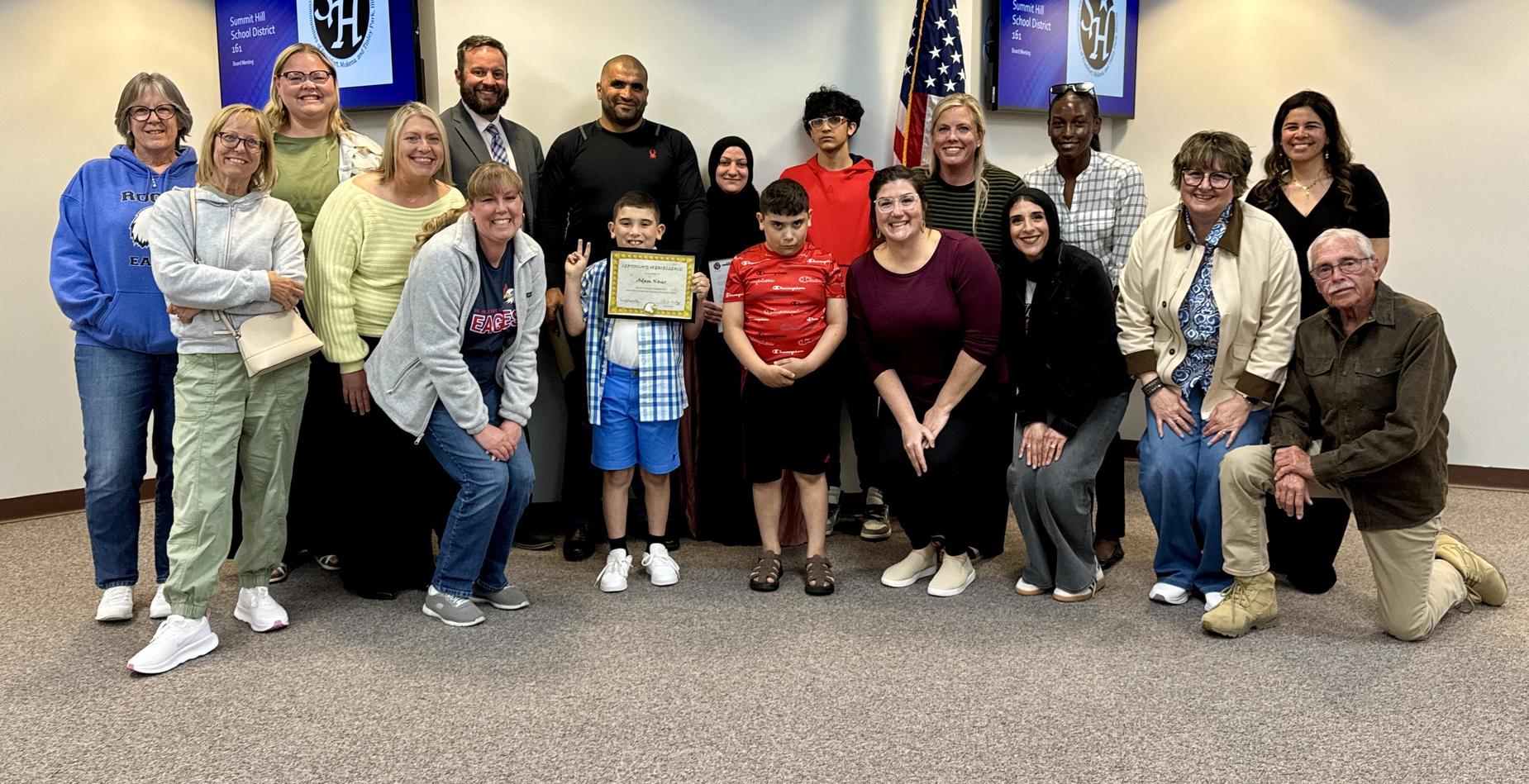 Group photo of the Dr. Julian Rogus School (grades 1-4) Exemplary Student pictured with his family and several Summit Hill 161 staff members after being recognized during the May Board of Education meeting.