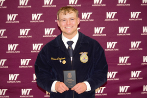 Gunner Claybrook poses in from of WTAMU back drop after winning 1st place at State FFA competition