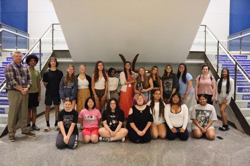 Student winners posing near steps inside the high school