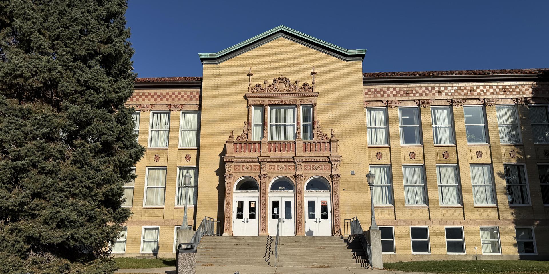 Historic school building with ornate entryway and large windows.