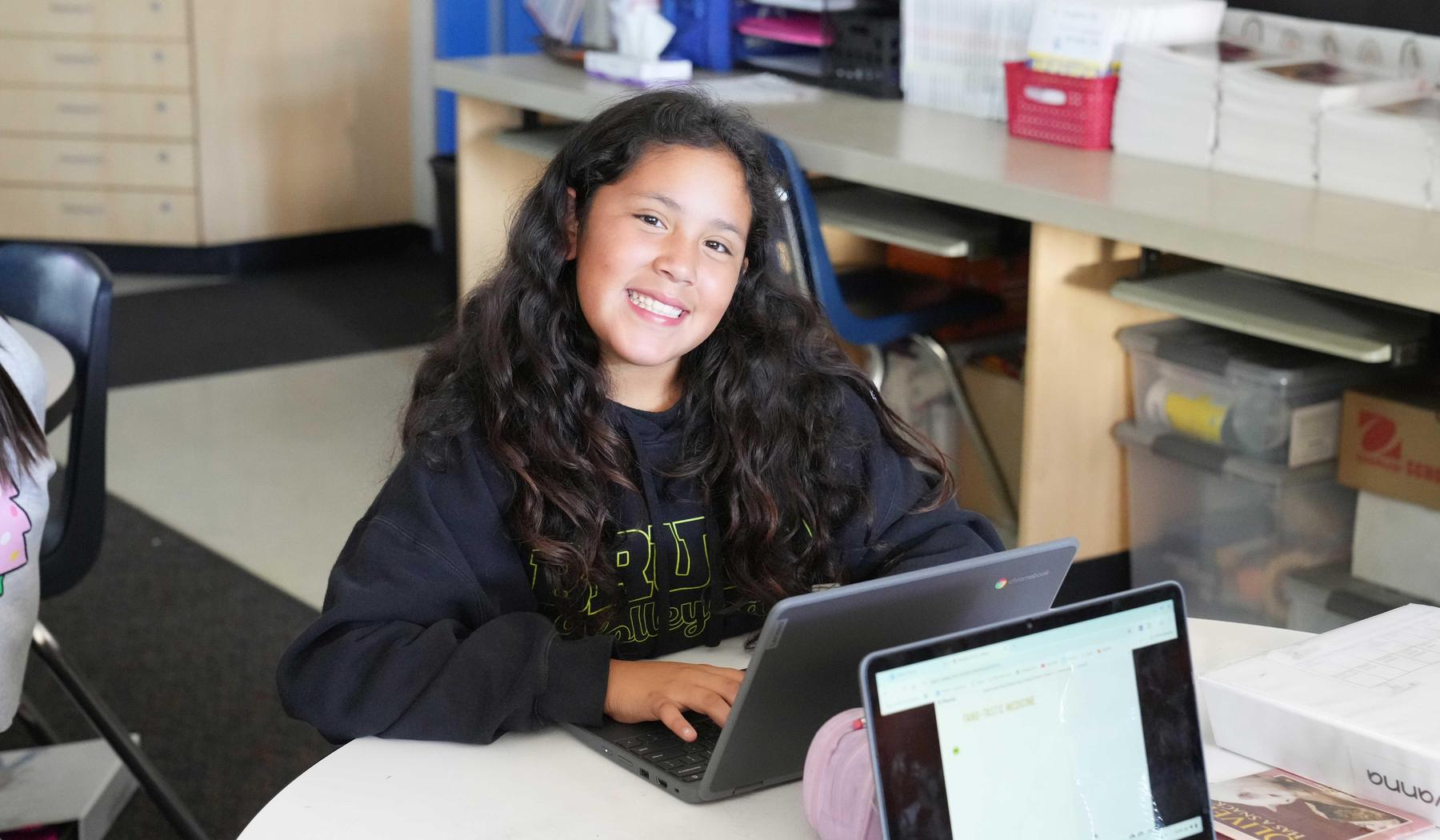 smiling student working on their chromebook