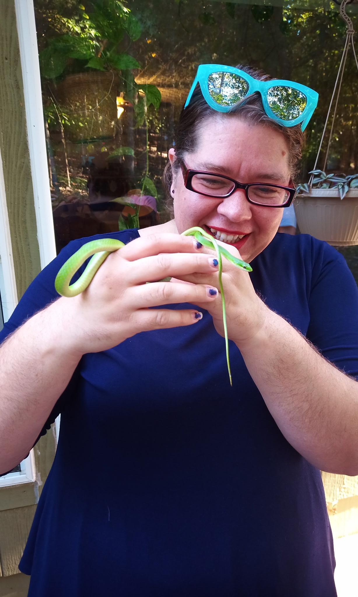 Teacher holds a grass snake in the woods