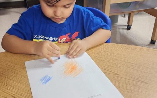 Boy drawing on paper.