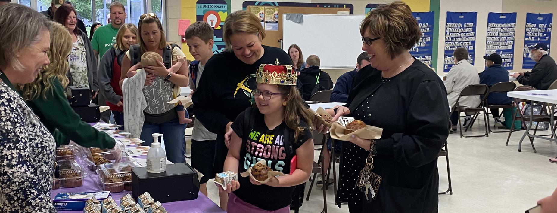 Student with a crown at muffins morning