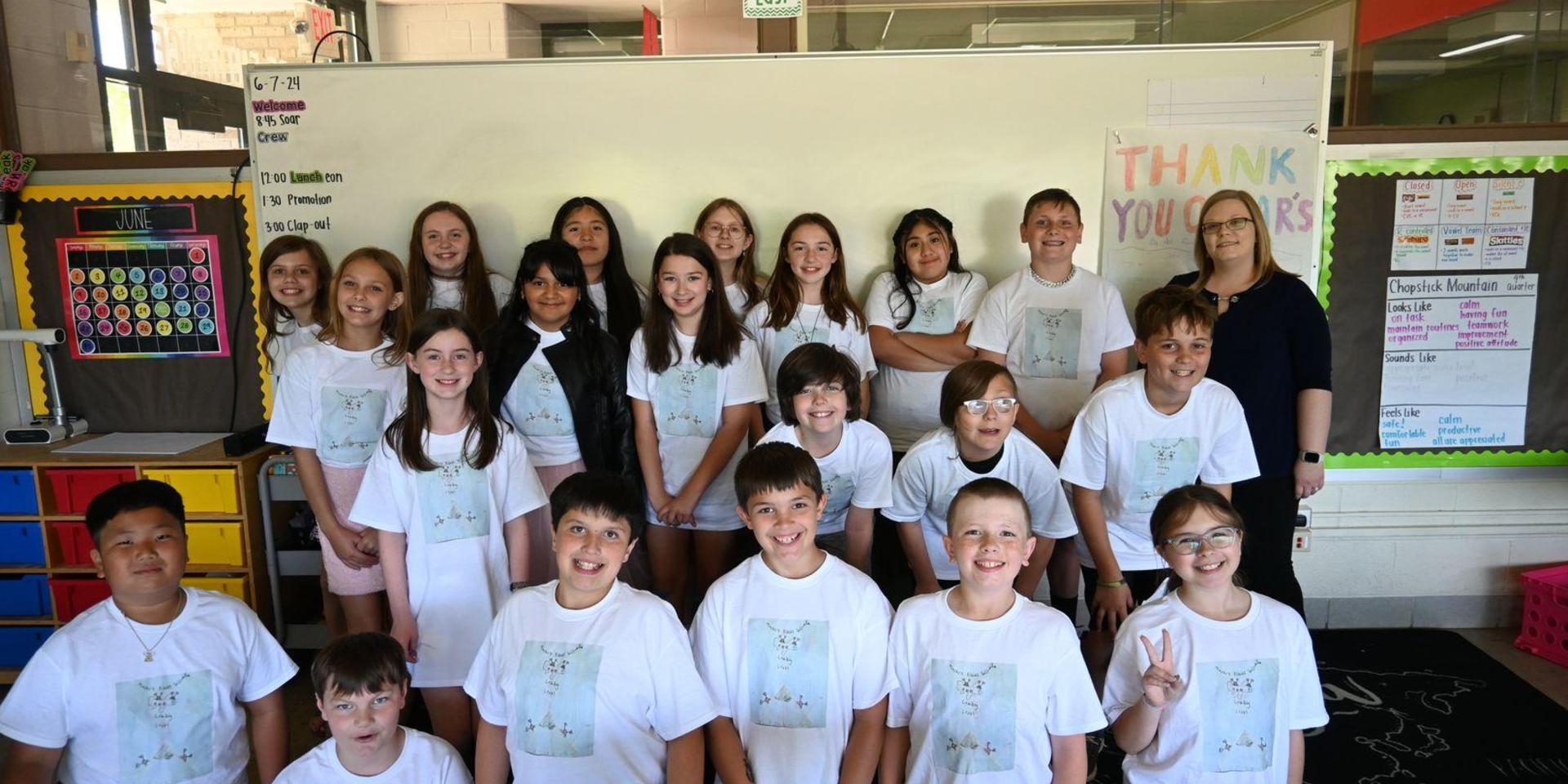 Class of students wearing matching shirts posing for a group photo.