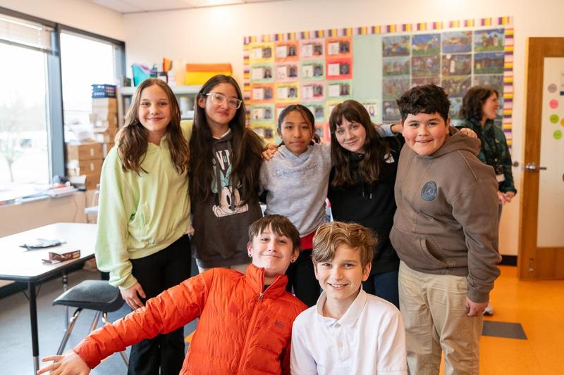 Students at Arco Iris Spanish Immersion school pose for a photo in a classroom.