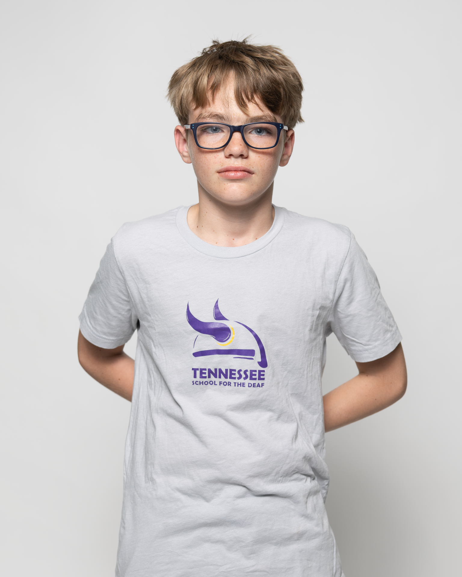Boy in a gray t-shirt with the Tennessee School for the Deaf logo.