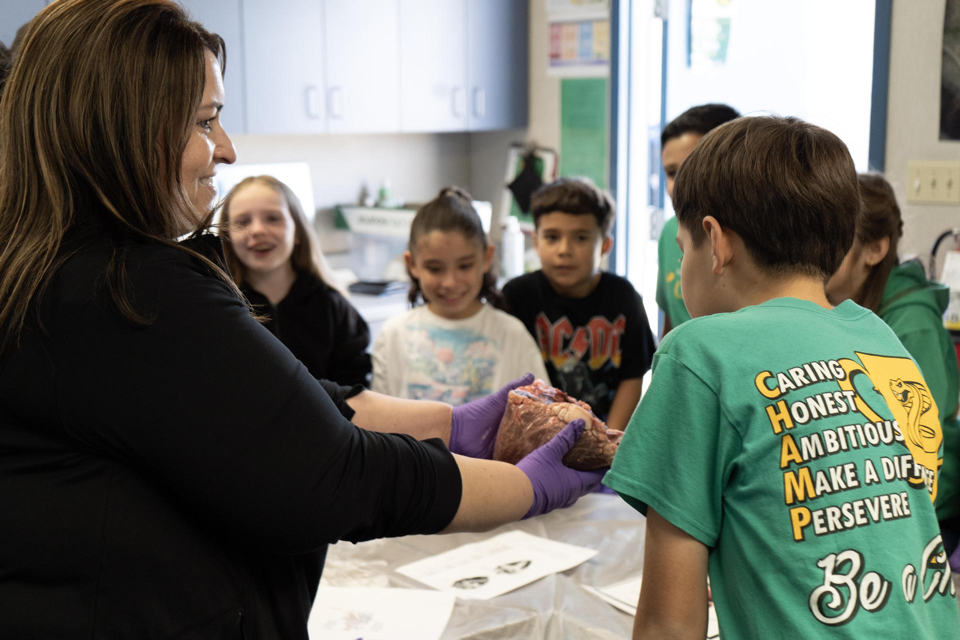 Students in classroom observing organ dissection with nursing staff.