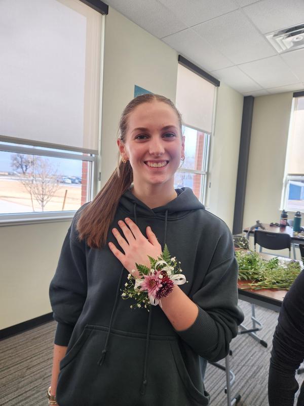 Thea Covelli holding her hand showing off the corsage she made.