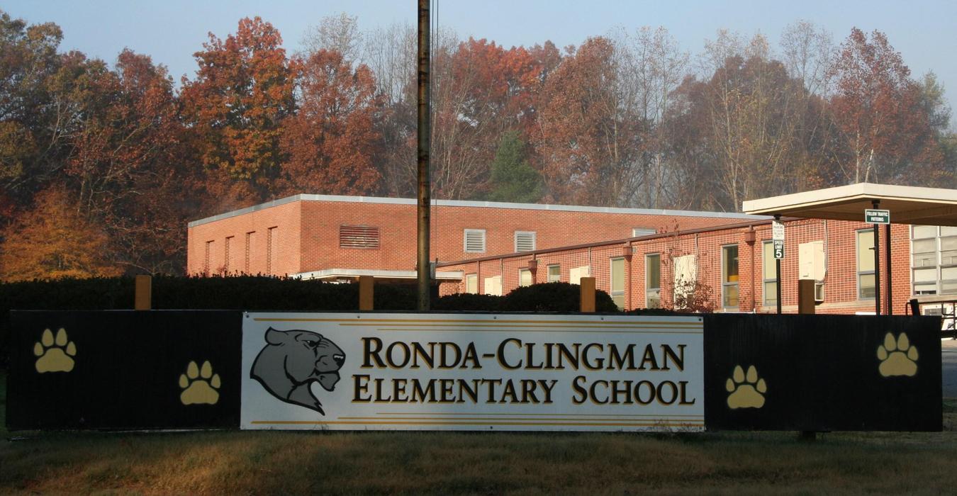 Sign for Ronda-Clingman Elementary School with trees in autumn colors behind.