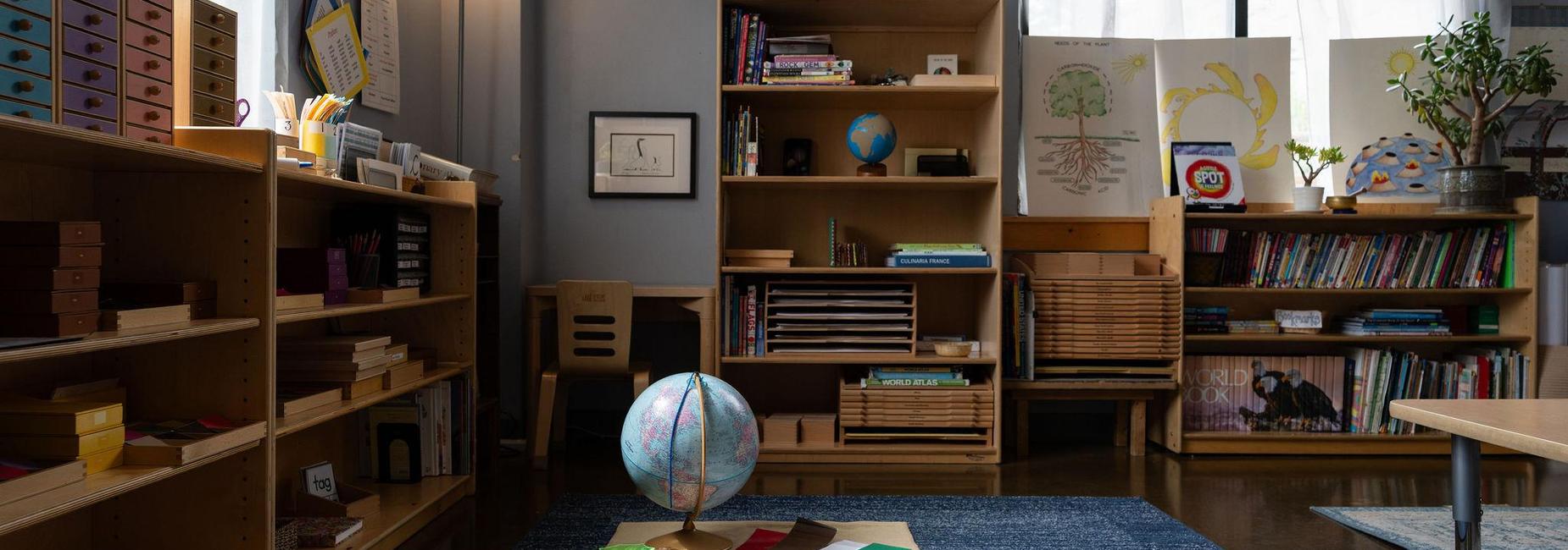 Cozy classroom with shelves of books and a globe in the center.