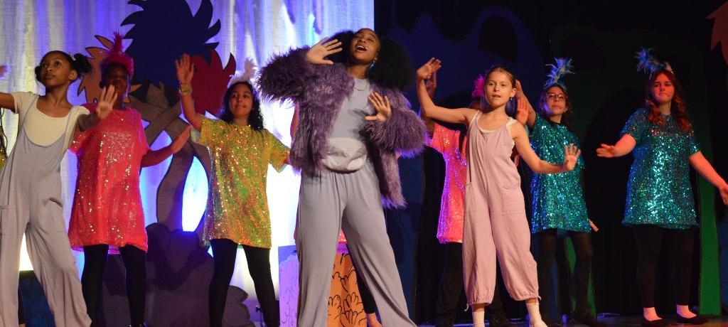 students in sequined dresses sing