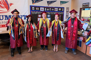 All five graduates hold up their awards in their graduate gowns