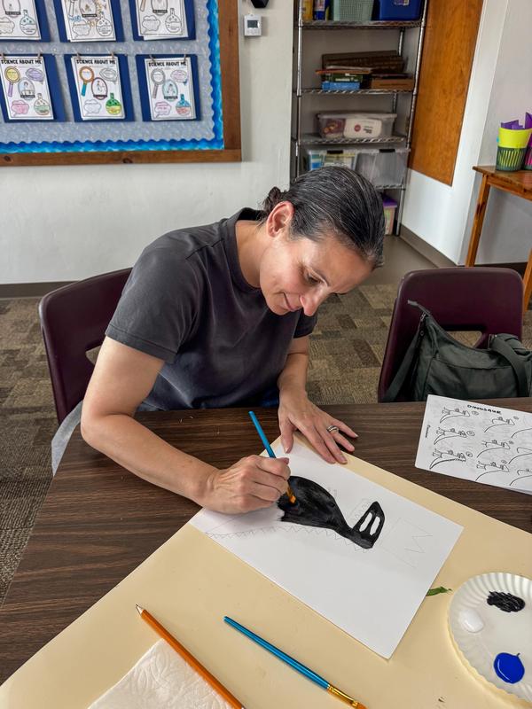 One volunteer looking down at her painting
