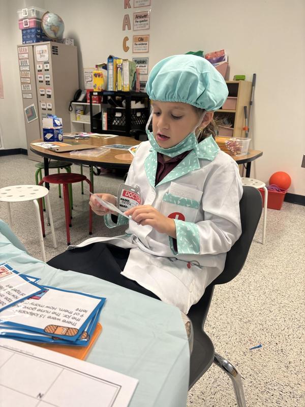 A second grade girl in the middle of performing "surgery"