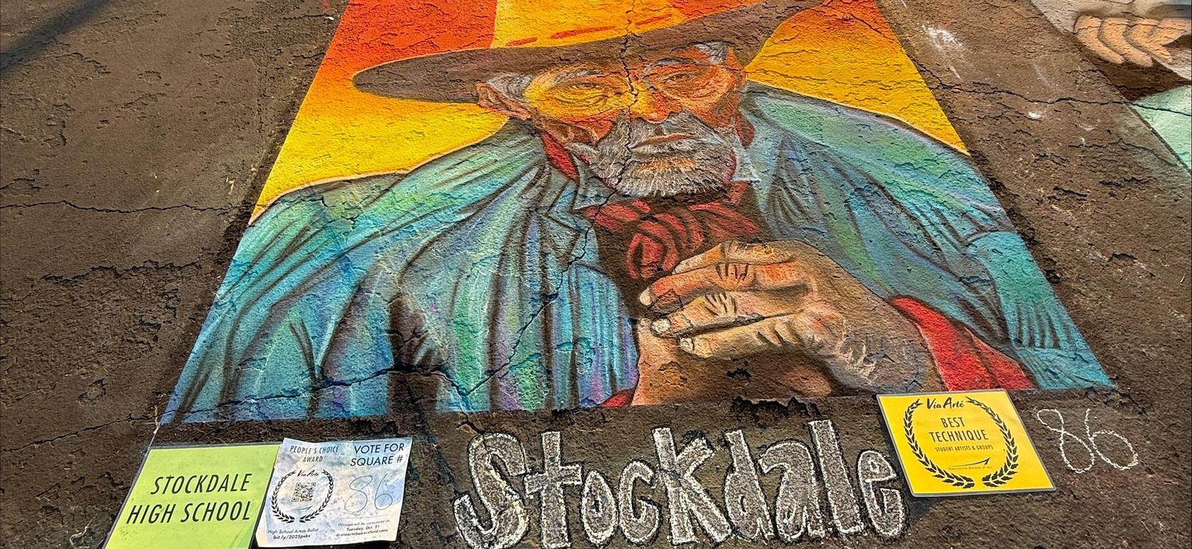 Colorful mural of a man with a hat, accompanied by school signs and a voting flyer.