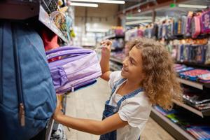 Preteen girl child choosing new backpack for school supplies