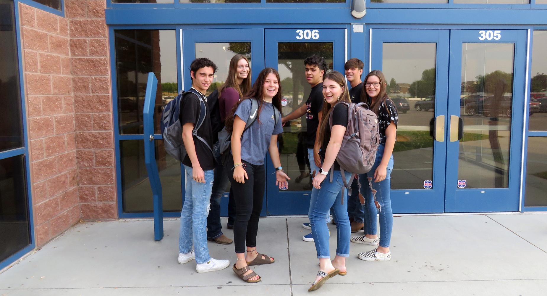 Seven high school-aged students prepare to enter the school.