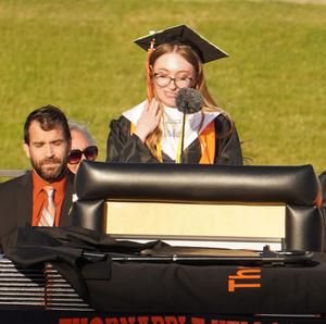 A graduate introduces the guest speaker.