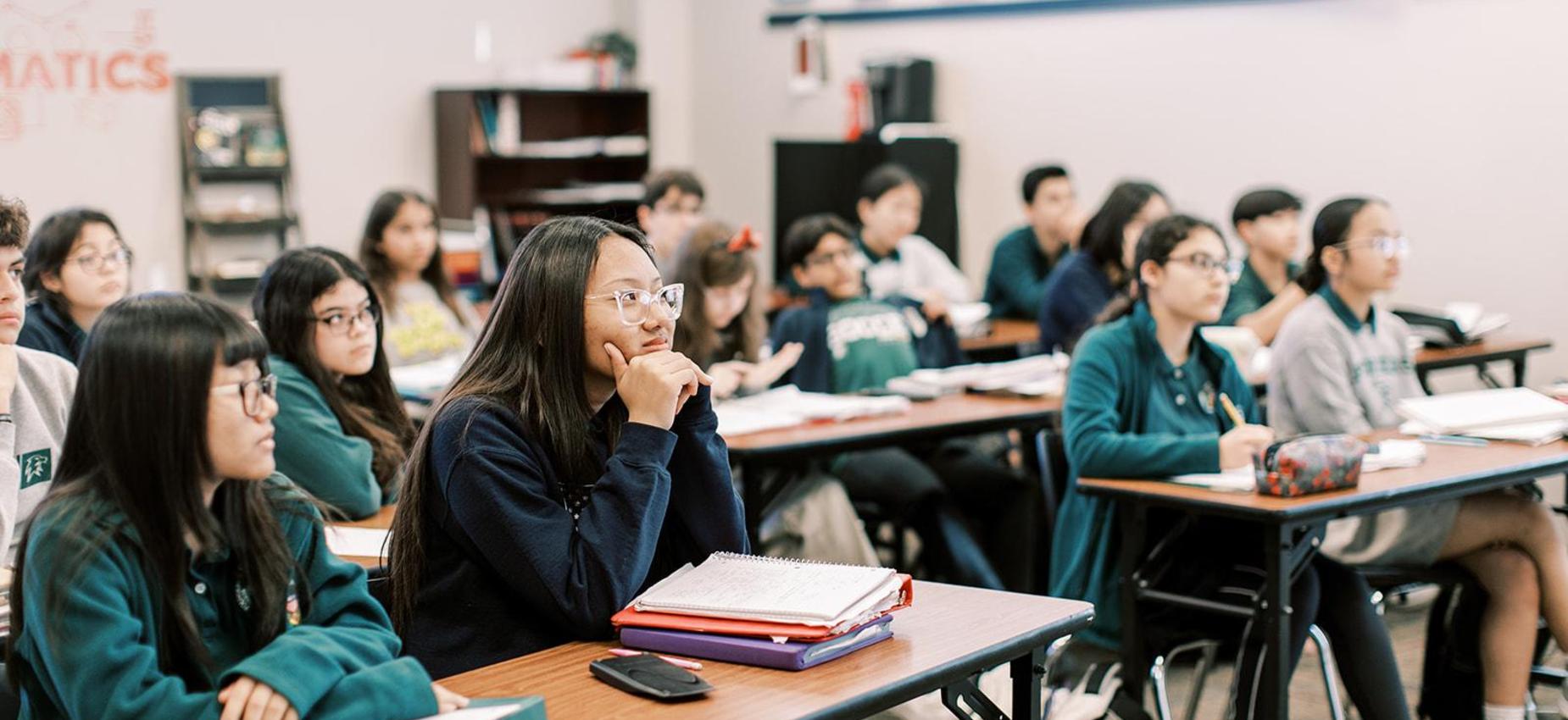 High school students listen and take notes during class