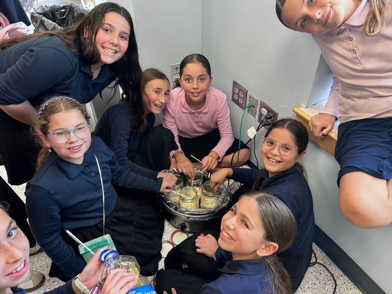 Sixth grade girls dip cake pops into melted chocolate