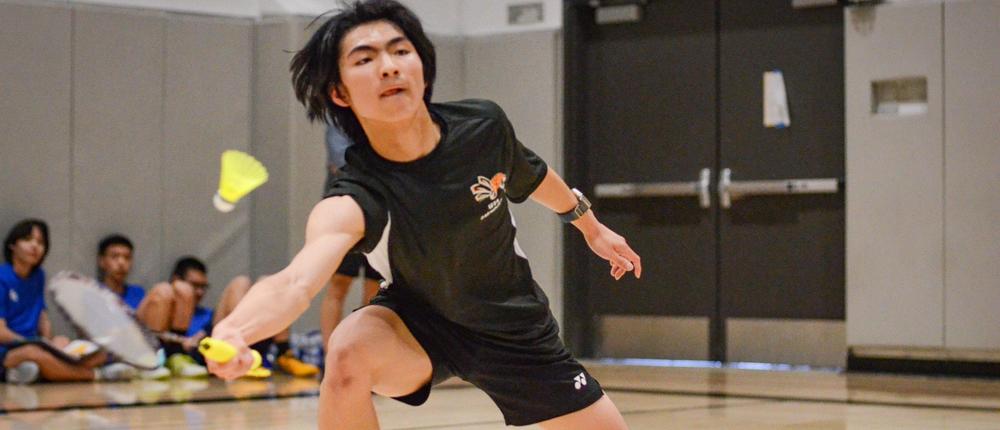 boy playing badminton in the gym