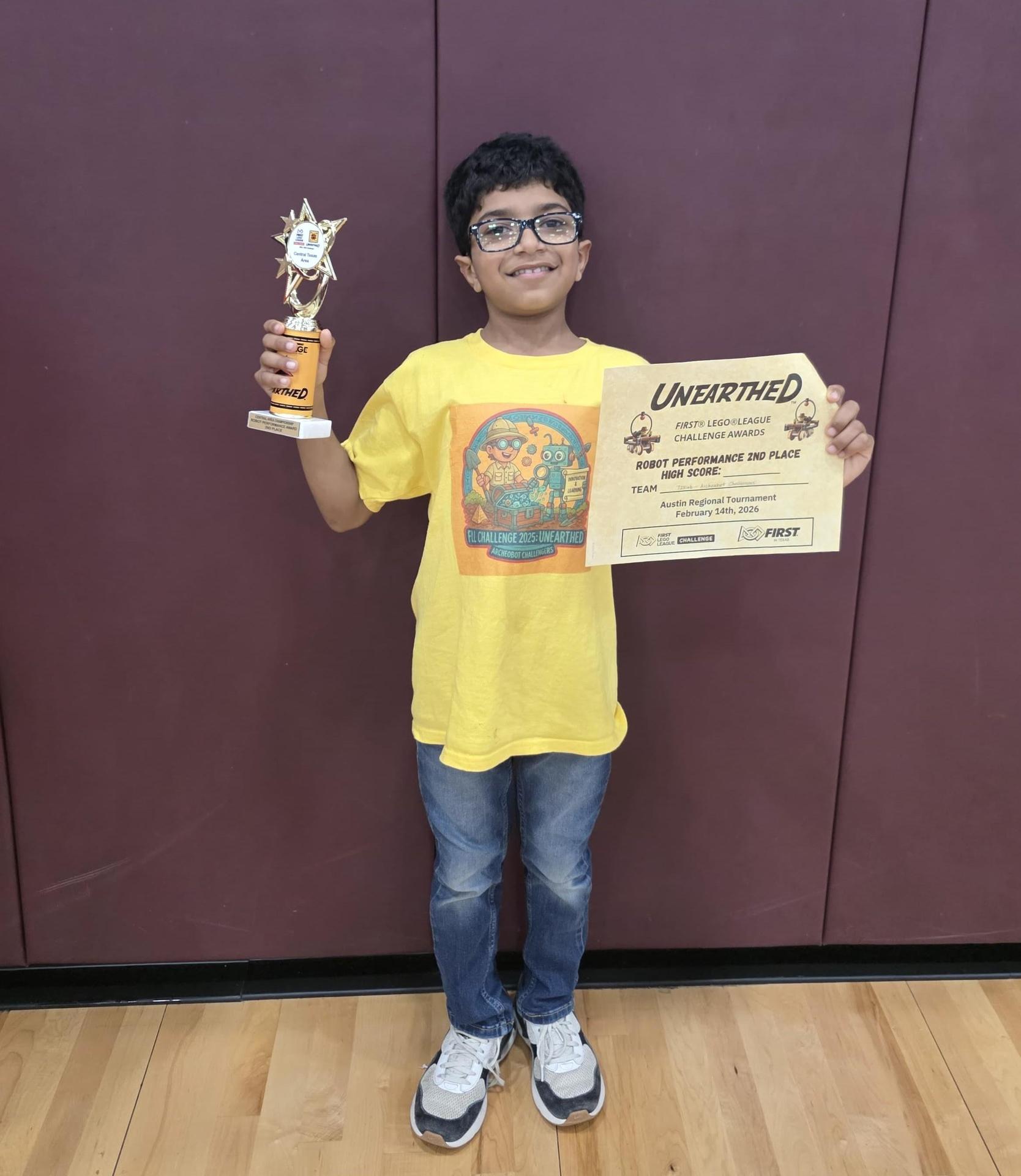 Student holds a trophy and certificate