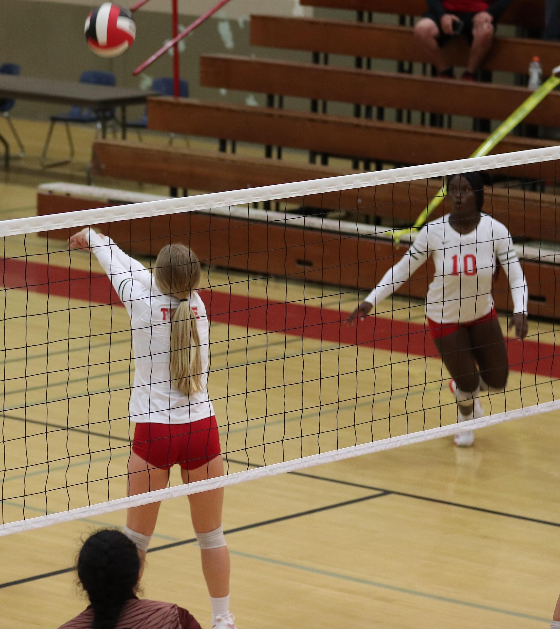 varsity volleyball players in action against Fresno Christian