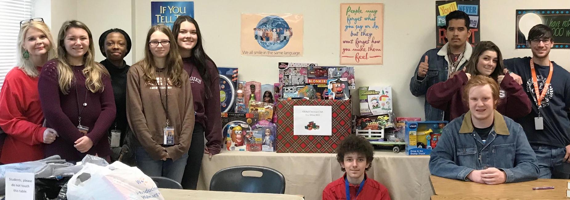group of 9 teen students and an instructor with donated toys