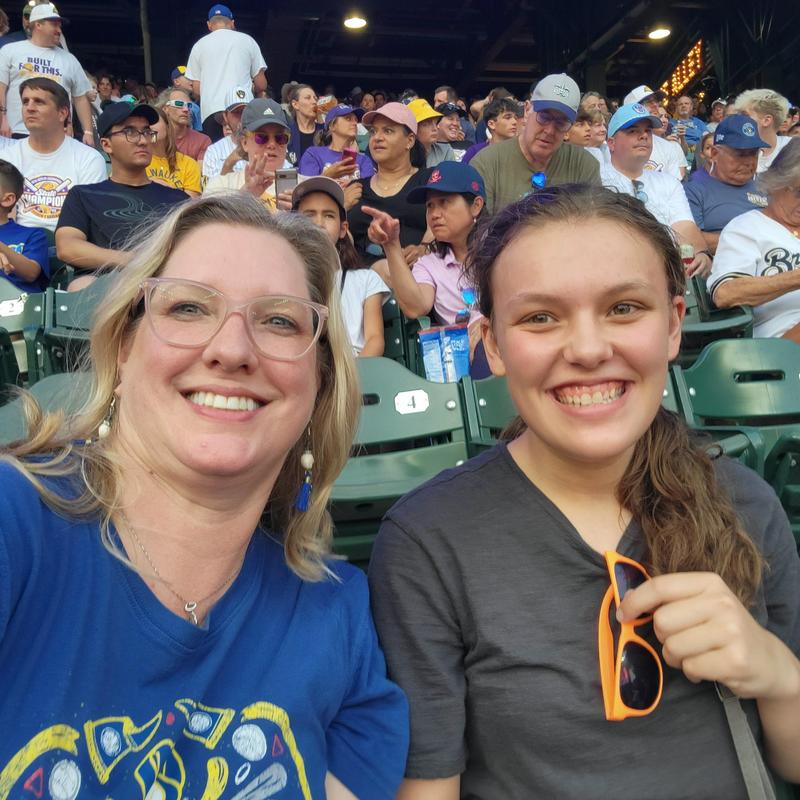 Two smiling women taking a selfie at a baseball game.