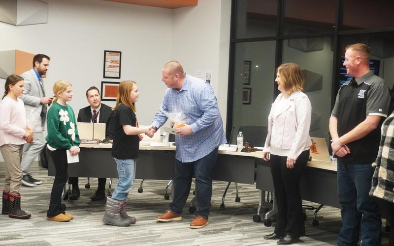 A Page student shakes hands with the TK Board President.